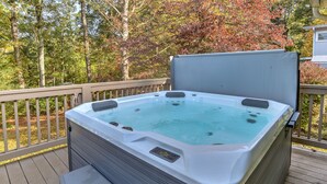 A hot tub on a wooden deck with a view of trees. - Updated home, hot tub, fire pit close to Asheville (Candler)