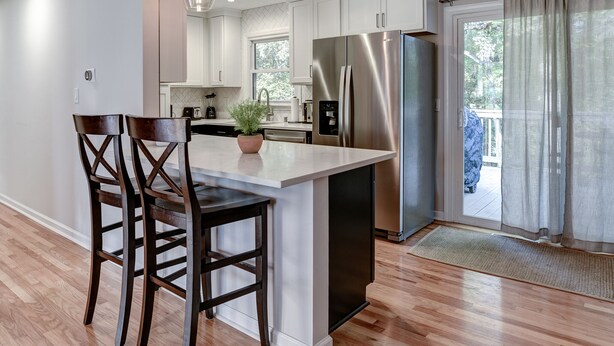 A modern kitchen with a central island, stainless steel appliances, and a sliding glass door to a balcony. - Updated home, hot tub, fire pit close to Asheville (Candler)