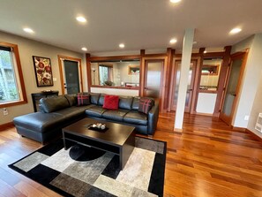 Ein modernes Wohnzimmer mit einer Eckcouch, einem Couchtisch und einem gemusterten Teppich.