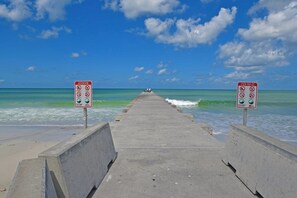 A pier leading to the ocean with signs indicating pier rules and attention to safety. - Runaway Bay 128 - Beach, Pool, gym and bay (Bradenton Beach)