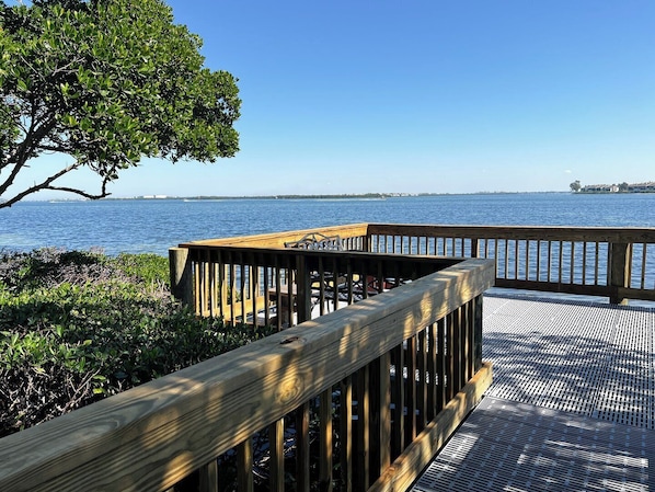 A wooden deck with a railing overlooking a body of water.