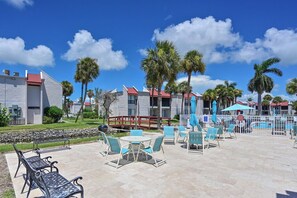 Un complexe hôtelier doté d’une terrasse, d’une piscine et de palmiers.