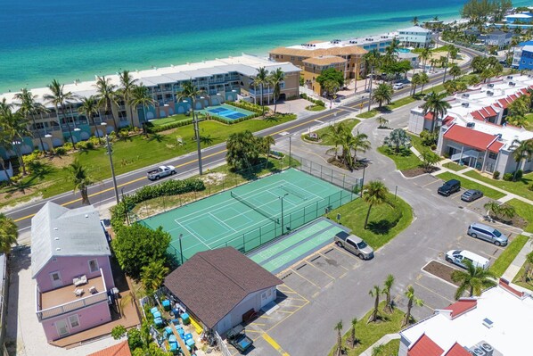A coastal hotel with a tennis court, pool, and beach access.