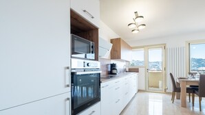 A modern kitchen with white cabinets, a built-in oven, and a coffee maker. - 3-Br. apartment near downtown Cannes. Sea view, parking. (Cannes)