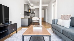 Uma sala de estar moderna com um sofá, mesa de centro e aparador para TV.
