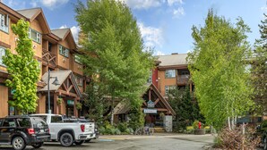 A hotel with a rustic architectural style, featuring a prominent wooden facade and a stone entrance.
