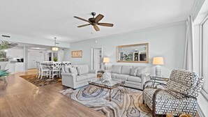 A spacious living room with a ceiling fan, a dining area with a chandelier, and a kitchen in the background. - $150 activities - E-gift card when you book - Upscale Coastal Vibe  | Margate Tower | M2703 (Myrtle Beach)