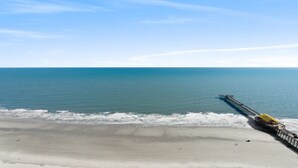 A beach with a pier extending into the ocean. - $150 activities - E-gift card when you book - Upscale Coastal Vibe  | Margate Tower | M2703 (Myrtle Beach)