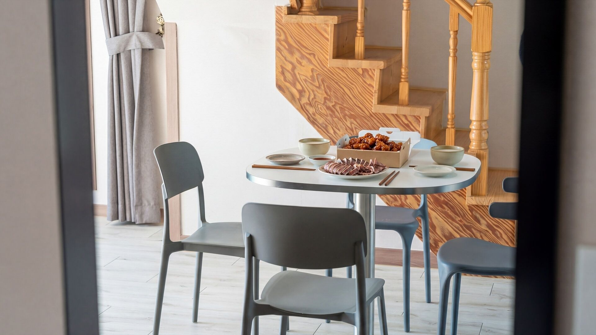 Un coin repas avec une table ronde, des chaises et une boîte de nourriture.