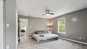 A bedroom with a bed, a ceiling fan, a nightstand, and a window. - Monthly pet-friendly, <5 min walk to beach (Hampton)