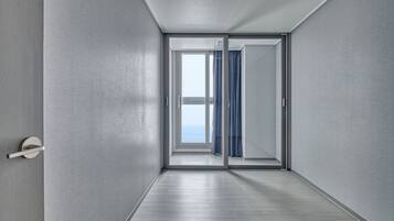 A modern hallway with a sliding glass door leading to a balcony with a view.