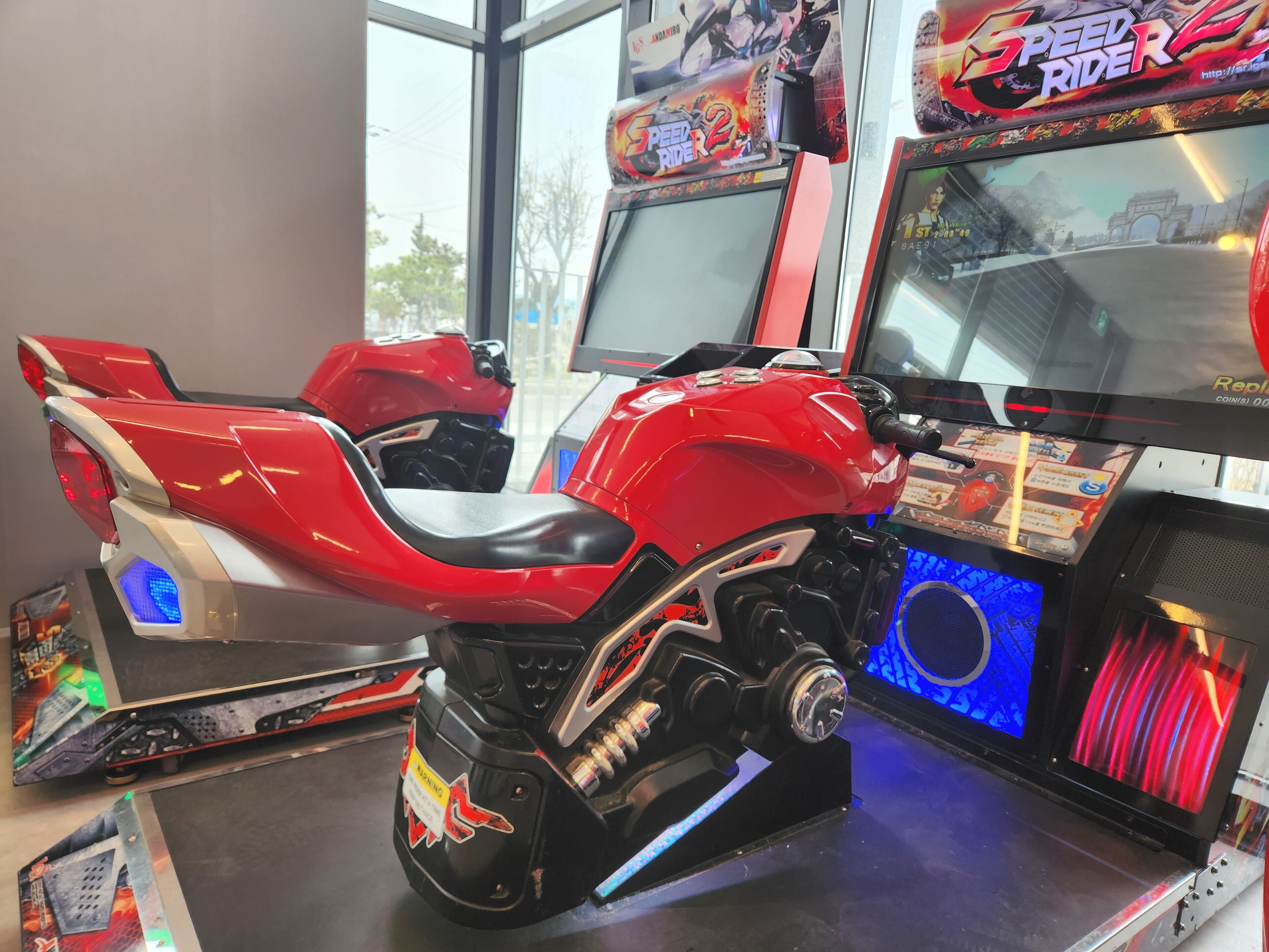 Ein rotes Arcade-Motorradspiel mit digitalem Display und Münzeinslot.