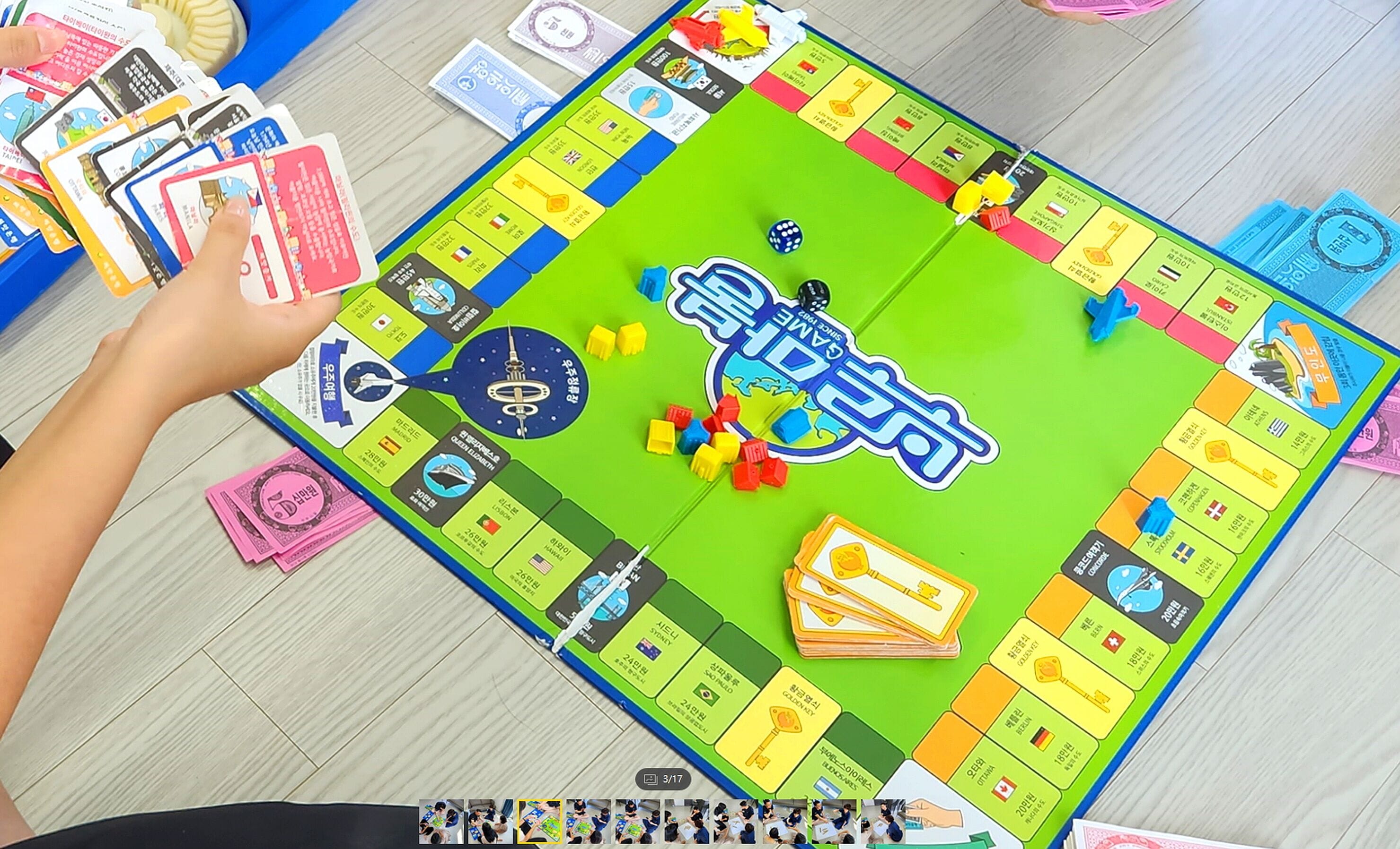 A board game with various colorful pieces and cards spread out on a wooden floor.