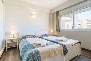 A hotel room with a bed, two bedside tables, a window, and a view of buildings outside. - Apartment 'Acapulco 6' close to the Beach with Shared Pool & Wi-Fi (Fuengirola)