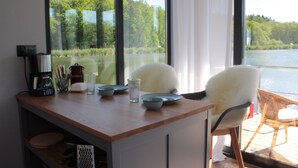 Un comedor con vista a un lago, una cafetera y un juego de sillas.