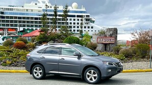 Un SUV gris estacionado frente al muelle de cruceros.