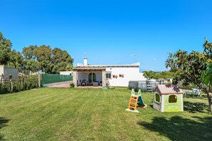 A house with a patio, a playhouse, and a fenced yard.