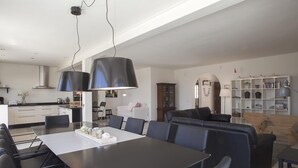 Eine moderne Küche mit Essbereich, ein Wohnzimmer mit einer Couch und einem Bücherregal.