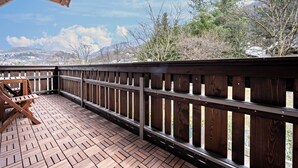 A wooden deck with a railing, a table, and chairs. - Apartment 'Plose 35' in strategic location with Mountain View, Balcony & Wi-Fi (Bressanone)