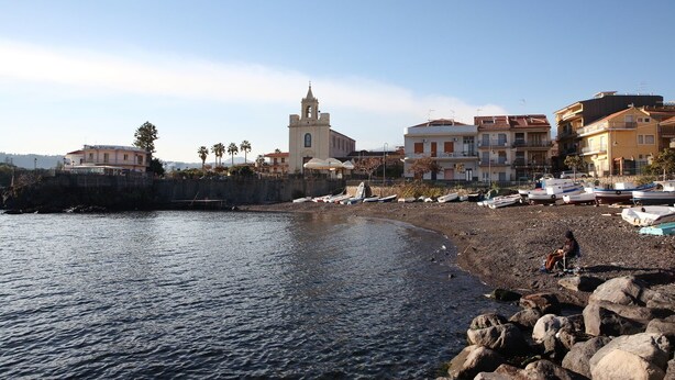A coastal town with a prominent church, rocky shoreline, and several boats. - Sicily new apartment next sea with two bedrooms (Acireale)