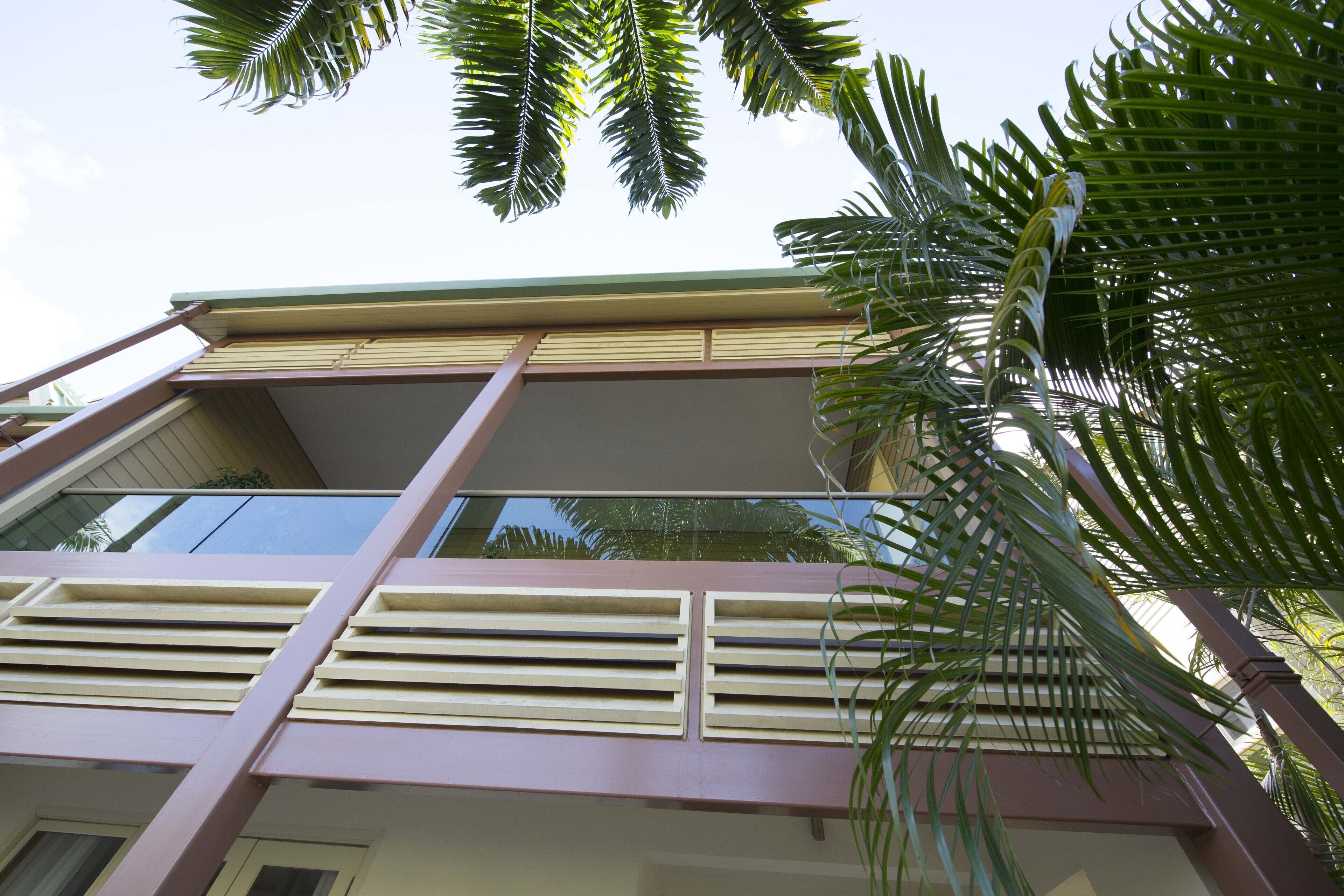 A multi-story building with a balcony and large windows.