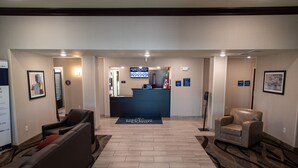 A reception area with a reception desk, seating area, and a carpeted floor. - Cobblestone Inn & Suites - Springfield (Springfield)