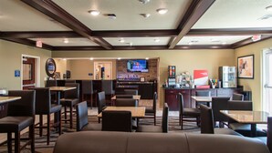 A hotel lobby with seating areas, a bar, and a television screen. - Cobblestone Inn & Suites - Springfield (Springfield)