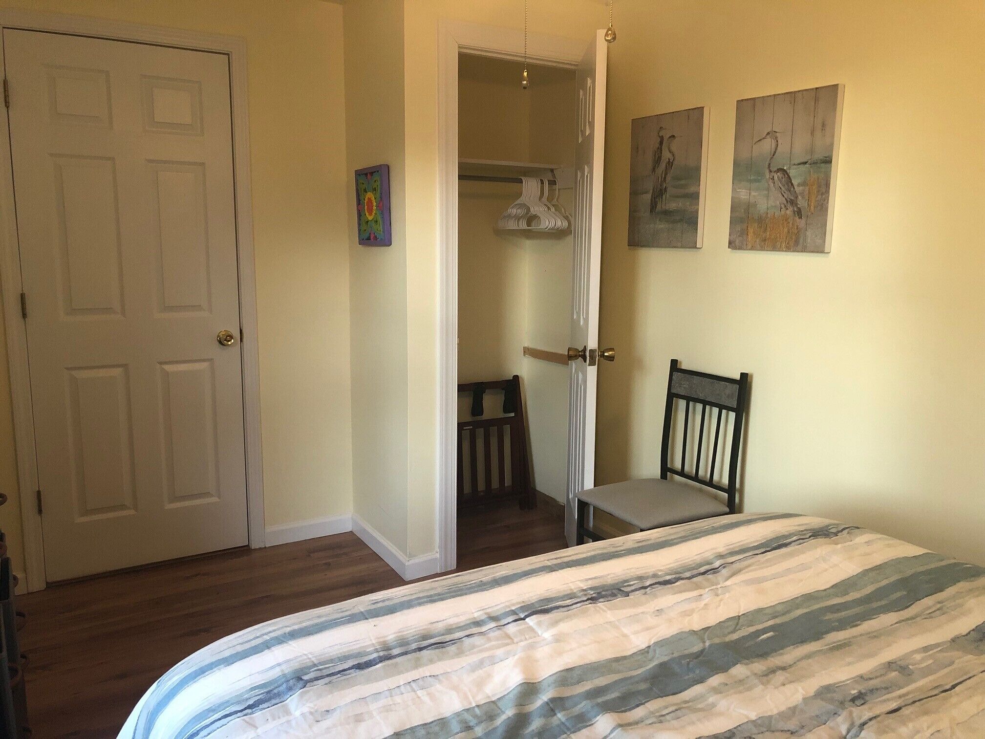 Une chambre à coucher avec un lit, une chaise, une porte et un placard.