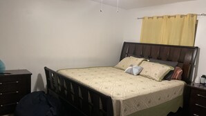 A bedroom with a bed, a bedside table, a chair, a desk, and a wardrobe. - Five minutes (Lauderhill)