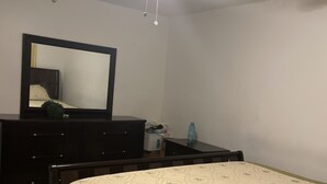 A bedroom with a bed, dresser, mirror, ceiling fan, and a small table with a vase. - Five minutes (Lauderhill)