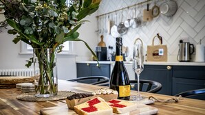 Une table en bois avec une bouteille de vin, un verre et des tranches de fromage.