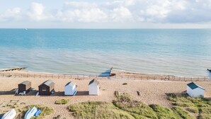 Une plage avec plusieurs petits cabanons et quelques chaises.