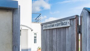 Une porte en bois sur laquelle est apposée une plaque indiquant : « Trafalgar Cottage ».
