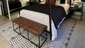 A four-poster bed with a bench, a patterned rug, and a mirror reflecting the room. - Palm Desert Luxury Condo -Country Club (Palm Desert)