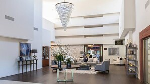 A spacious lobby with a chandelier, seating area, and a fireplace. - Palm Desert Luxury Condo -Country Club (Palm Desert)