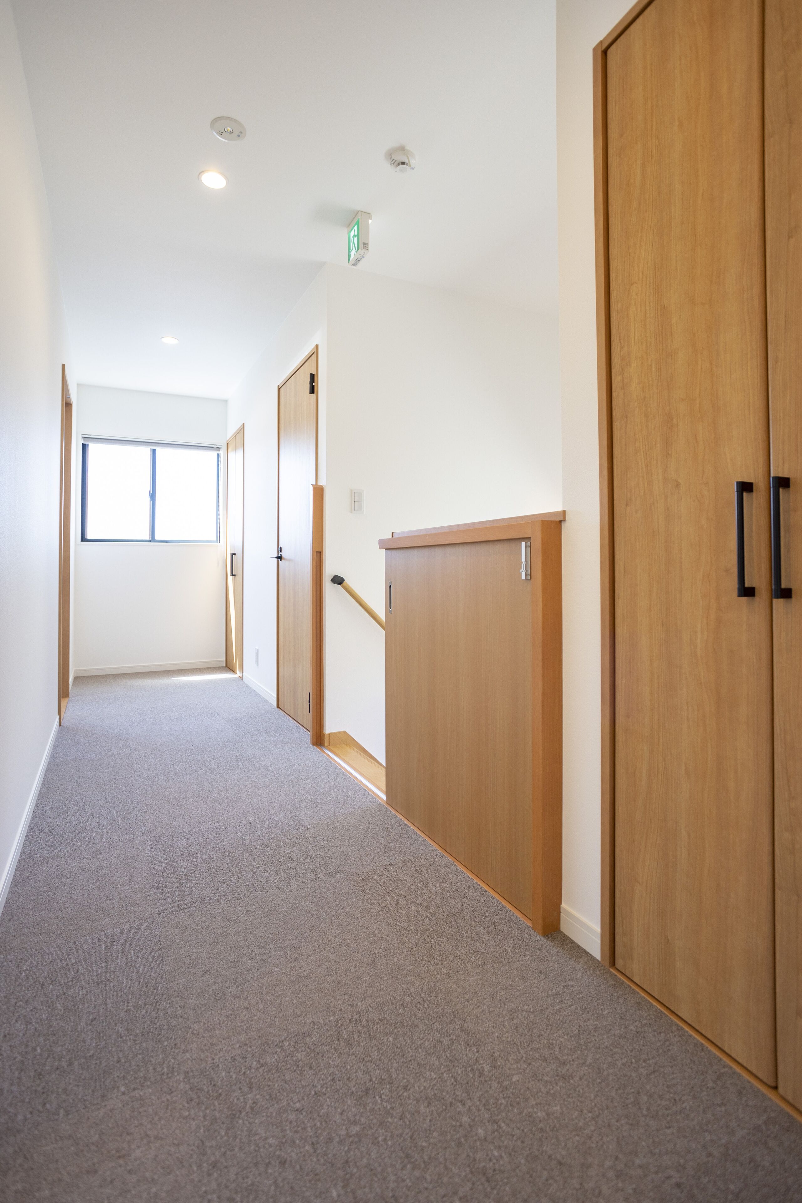 A hallway with wooden doors and a carpeted floor.