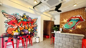 A vibrant skateboarding-themed restaurant interior with graffiti art, red bar stools, and a brick wall. - Rucksack Inn Temple Street (Singapore)