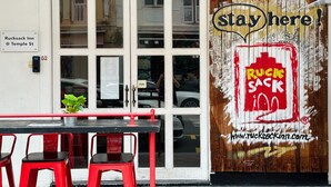 A building with a sign reading "Ruck Sack Inn @ Temple St" and a large mural with the text "stay here!" and "RUCK SACK". - Rucksack Inn Temple Street (Singapore)