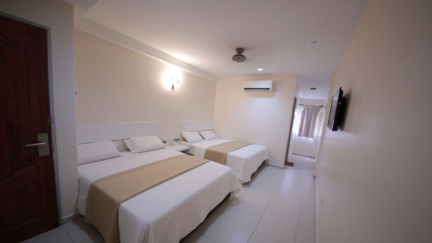 A hotel room with two beds, a ceiling fan, an air conditioning unit, and a television on the wall. - Skudai Hotel Universiti Teknologi Malaysia (Johor Bahru)