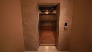 An elevator with a metallic interior and a control panel on the right. - Skudai Hotel Universiti Teknologi Malaysia (Johor Bahru)