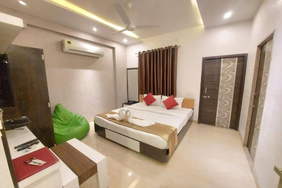 Une chambre d’hôtel moderne équipée d’un lit, d’un bureau, d’un fauteuil en forme de haricot vert et d’un ventilateur de plafond.