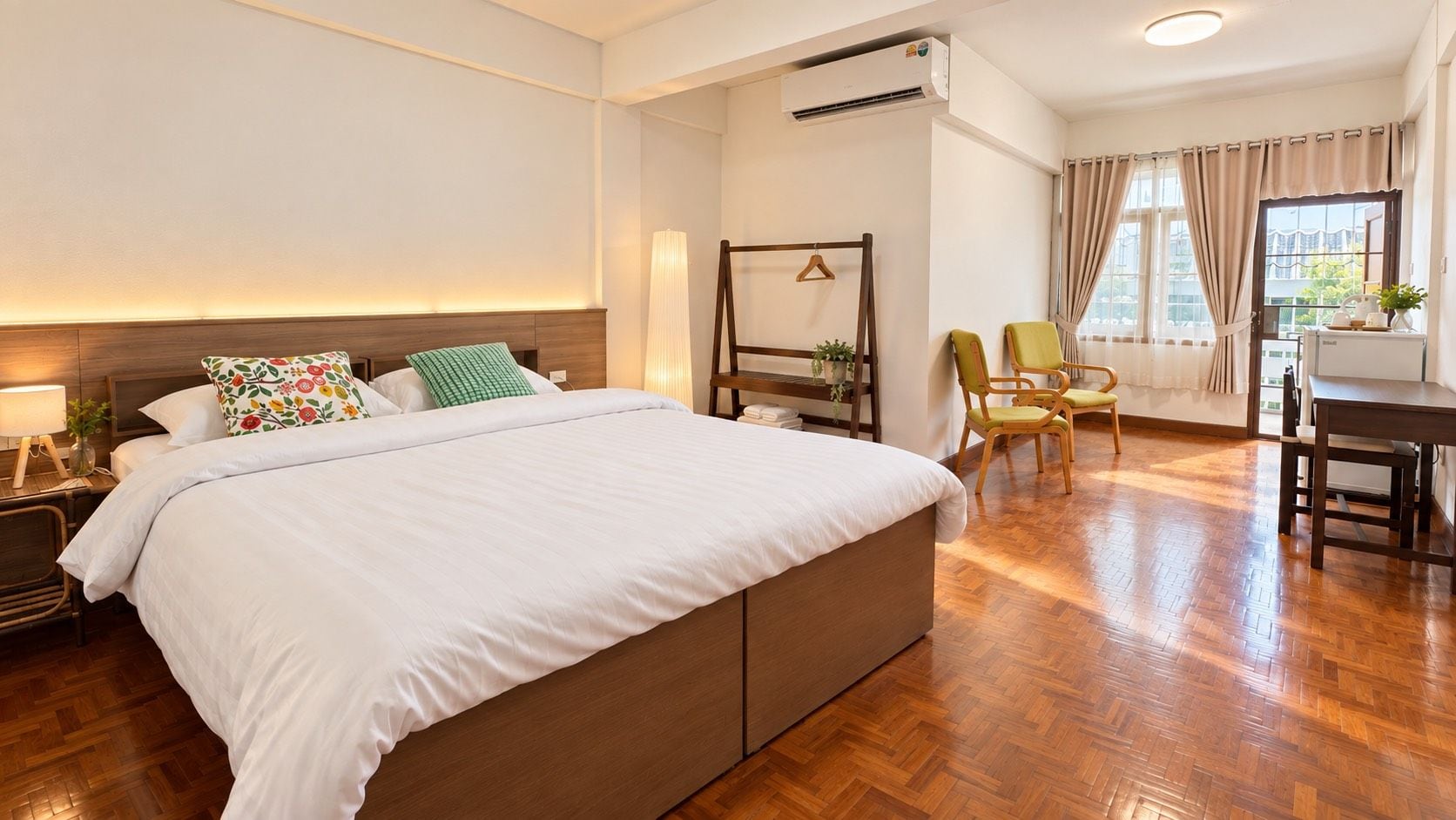 Habitación de hotel con una cama grande, un escritorio, sillas y vistas al exterior.