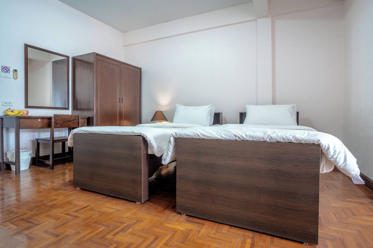 A bedroom with a bed, a desk, a chair, and a wardrobe.