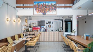 A modern cafe with a high ceiling, wooden accents, and a central counter with a coffee menu. - Sabai house (Chiang Mai)