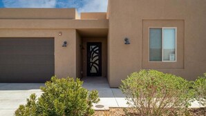 A modern building with a garage, a decorative entrance, and a window. - Charlotte: Large Groups + Private Hot Tub + Roof Top Deck (Hurricane)