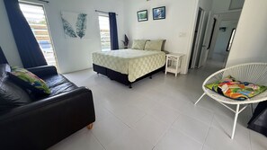Een slaapkamer met een bed, een bank, een stoel en een kleine tafel.