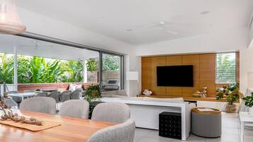 Relax in a spacious living area with a dining table, sofas, and a flat-screen TV.
