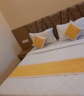 A hotel room with a bed, a headboard, and two nightstands. - Hotel Fun Park Sanand (Sanand)