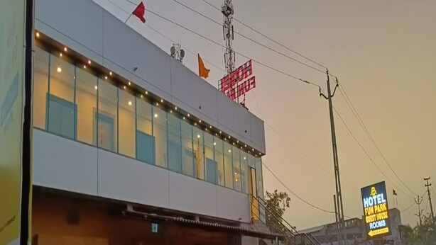 A hotel with a modern facade, multiple windows, and a sign indicating guest rooms. - Hotel Fun Park Sanand (Sanand)