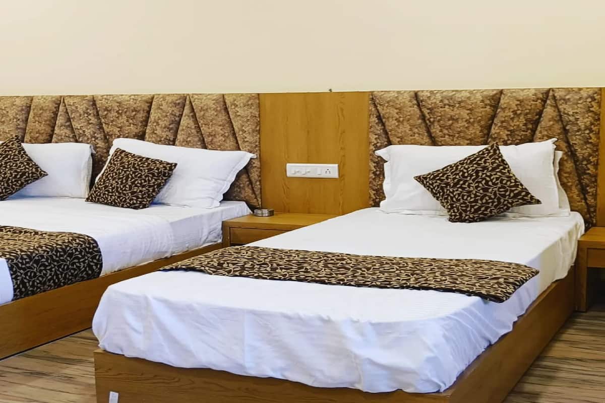 Two twin beds with patterned pillows and a wooden headboard.